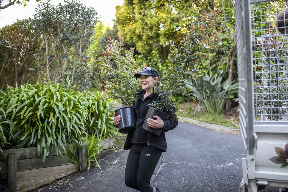 Carrying pot plants with a smile down the drive
